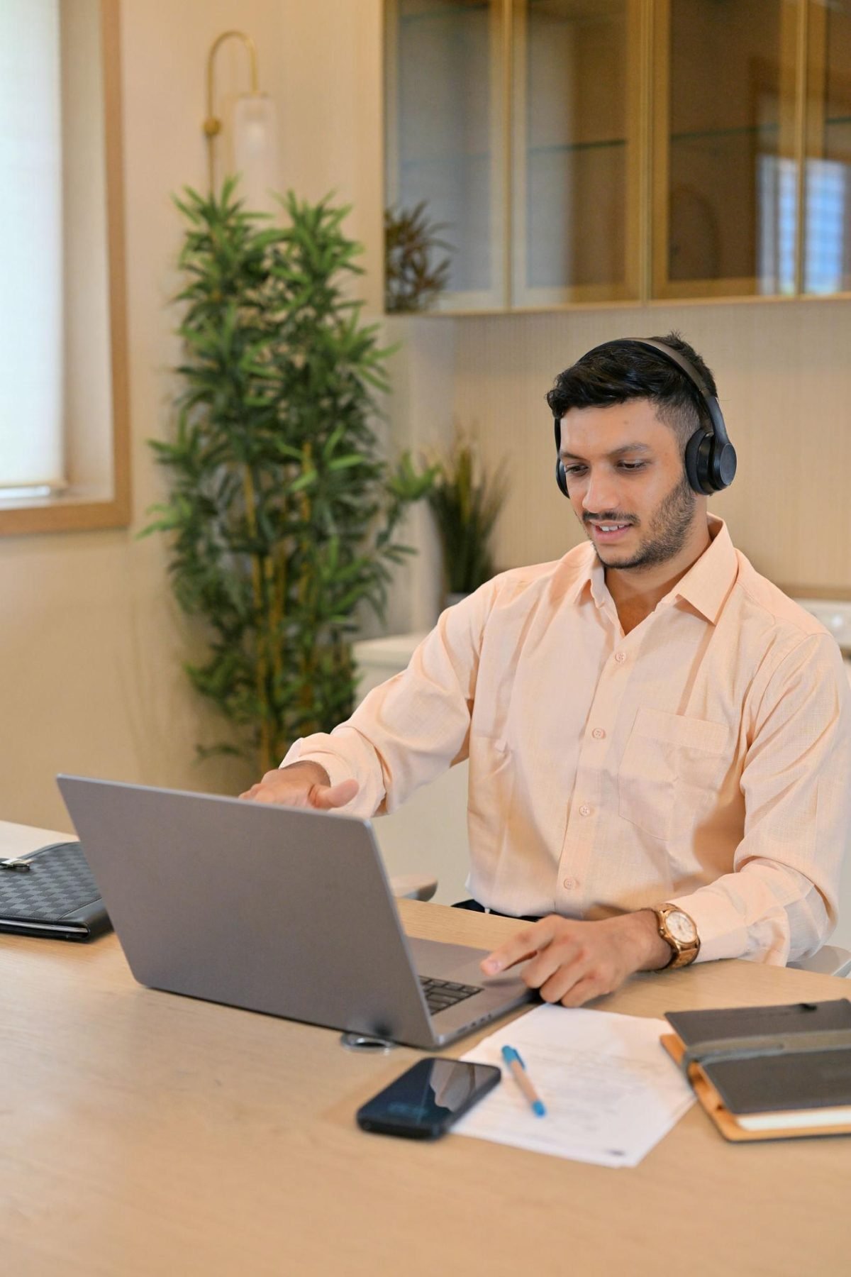 Accounting professional with headphones working remotely at a laptop